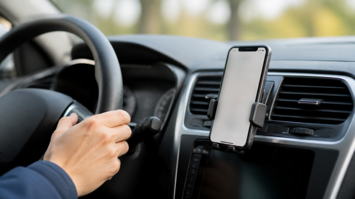 Smartphone in Halterung im Auto als Titelbild zum Handyverbot am Steuer